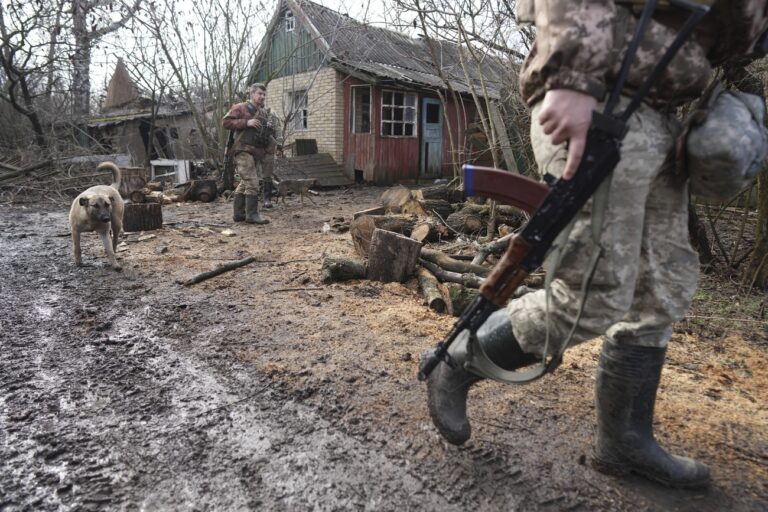 A Ukrainian serviceman walks to his position at the line of separation between Ukraine-held territory and rebel-held territory near Svitlodarsk, eastern Ukraine, Wednesday, Feb. 23, 2022. U.S. President Joe Biden announced the U.S. was ordering heavy financial sanctions against Russia, declaring that Moscow had flagrantly violated international law in what he called the 