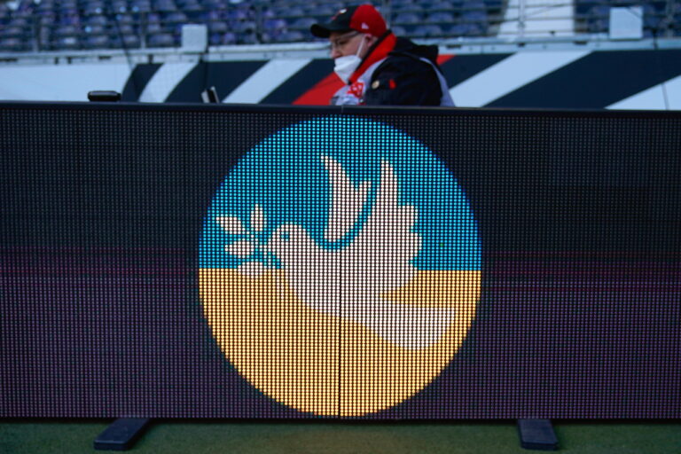 epa09787047 A digital display board shows a peace pigeon on a flag of Ukraine before the German Bundesliga soccer match between Eintracht Frankfurt and FC Bayern Munich in Frankfurt, Germany, 26 February 2022. EPA/RONALD WITTEK CONDITIONS - ATTENTION: The DFL regulations prohibit any use of photographs as image sequences and/or quasi-video.