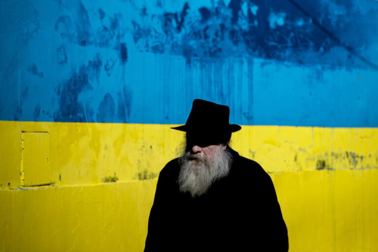 epa09809968 A man walks past a large Ukrainian flag painted on wall, in Prague, Czech Republic, 08 March 2022. Some 100.000 refugees from Ukraine have arrived in the Czech Republic so far, most of them women, children, and elderly people, since the beginning of Russia's invasion of Ukraine. EPA/MARTIN DIVISEK