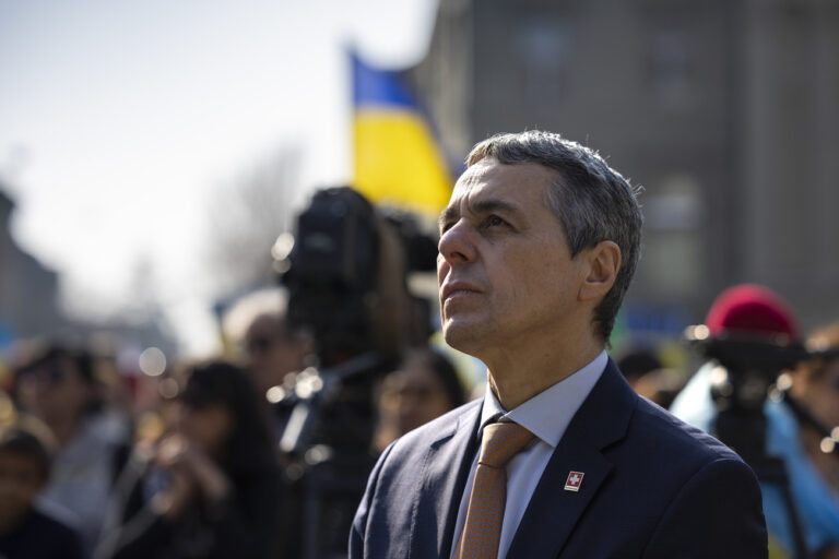 Swiss Federal President Ignazio Cassis listens to the speech of Ukrainian President Volodymyr Zelensky, during a demonstration against the Russian invasion of Ukraine in front of the Swiss parliament building in Bern, Switzerland, Saturday, March 19, 2022. (KEYSTONE/Peter Klaunzer)