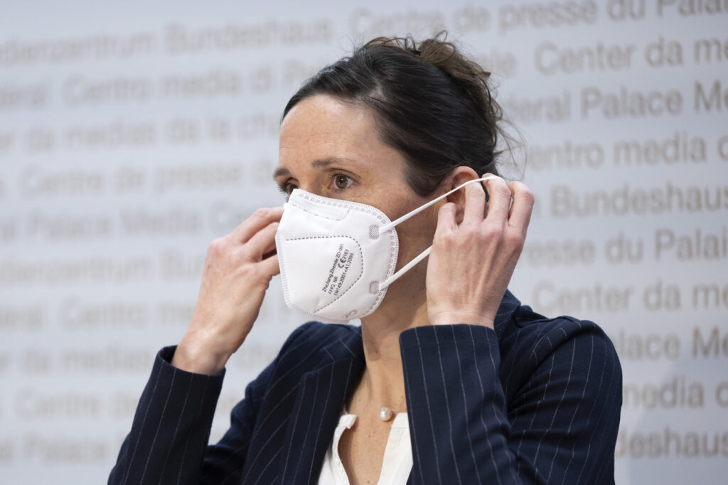 Tanja Stadler, Praesidentin National COVID-19 Science Task Force, zieht eine Maske an, waehrend einer Medienkonferenz zur aktuellen Situation des Coronavirus, am Dienstag, 22. Maerz 2022 in Bern. (KEYSTONE/Peter Klaunzer)