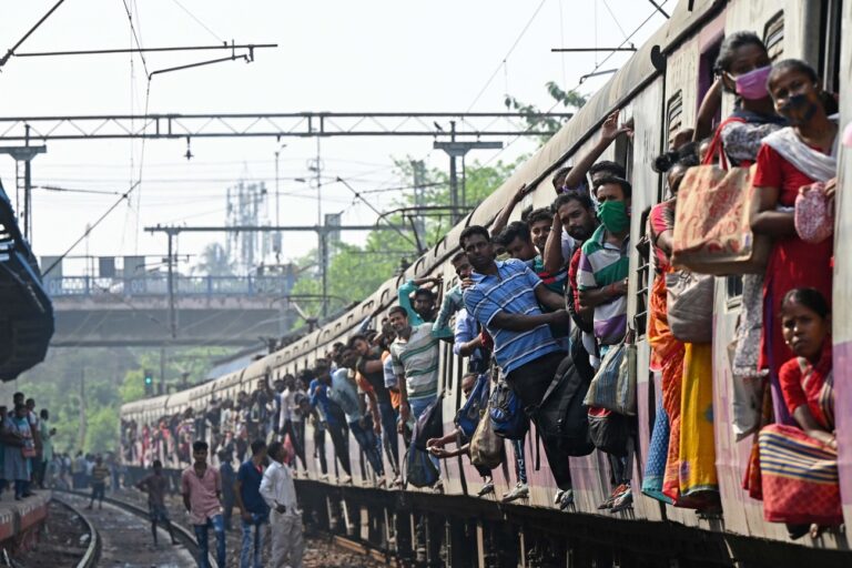 TOPSHOT - Commuters watch after their train was blocked by leftist activists at a railway station during a nationwide general strike against the policies of the central government in Kolkata on March 28, 2022. (Photo by Dibyangshu SARKAR / AFP) (KEYSTONE/AFP/DIBYANGSHU SARKAR)