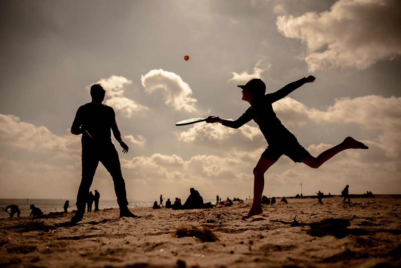 14.04.2022, Niedersachsen, Schillig: Ein Vater und sein Sohn spielen bei schönem Wetter und Sonnenschein Beach-Tennis am Nordseestrand von Schillig. Foto: Mohssen Assanimoghaddam/dpa +++ dpa-Bildfunk +++ (KEYSTONE/DPA/Mohssen Assanimoghaddam)