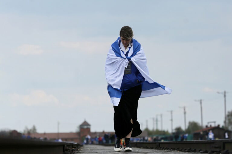 epa09914370 A person wearing an Israeli national flag takes part in the 'March of the Living' at the former Nazi concentration camp of Auschwitz in Oswiecim, Poland, 28 April 2022. The annual Holocaust-commemorating 'March of the Living' takes place on the site of the wartime German Nazi death camp Auschwitz-Birkenau. 'Marches of the Living' have been organised since 1988 to commemorate Holocaust Remembrance Day. EPA/Zbigniew Meissner POLAND OUT