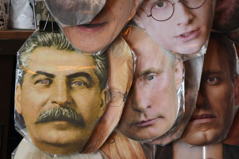 Face masks depicting Russian President Vladimir Putin, centre, Soviet dictator Josef Stalin, left, and and jailed Russian opposition leader Alexei Navalny, right, among others are displayed for sale at a street souvenir shop in St. Petersburg, Russia, Sunday, May 1, 2022. (AP Photo)