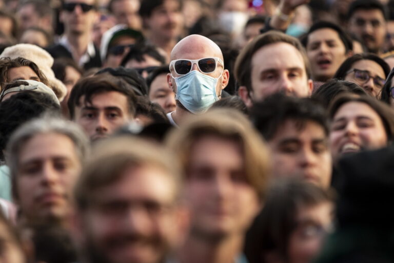 epa09964883 A fan wearing a face mask watches US band 'The Shins' perform on stage during the Just Like Heaven festival in Pasadena, California, USA, 21 May 2022. EPA/ETIENNE LAURENT