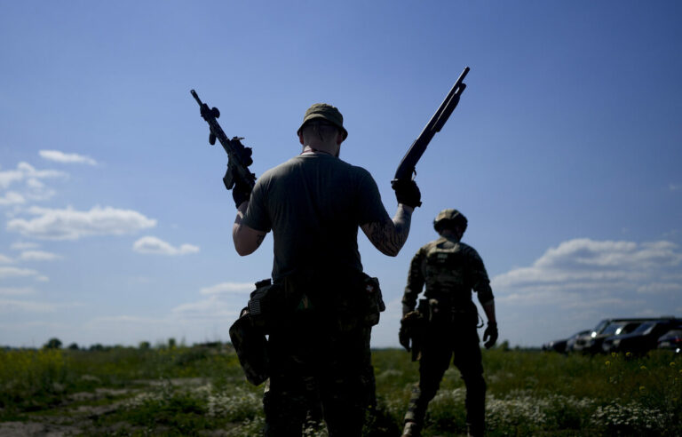 A civilian militia man holds a shotgun and a rifle during training at a shooting range in outskirts Kyiv, Ukraine, Tuesday, June 7, 2022. (KEYSTONE/AP Photo/Natacha Pisarenko)