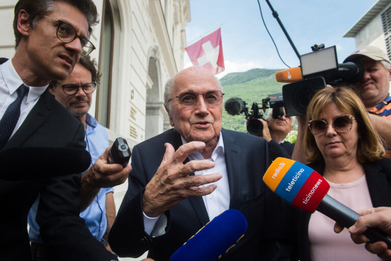 The former president of the World Football Association (Fifa), Joseph Blatter, center, surrounded by media representatives, delivers statements to the press at the Swiss Federal Criminal Court in Bellinzona, Switzerland, after the first day of his trial, Wednesday, June 8, 2022. Blatter and the former president of the the European Football Association (Uefa), Michel Platini, stand trial before the Federal Criminal Court from Wednesday, over a suspicious two-million payment. The Federal Prosecutor's Office accuses them of fraud. The defense speaks of a conspiracy. (KEYSTONE/Ti-Press/Alessandro Crinari)