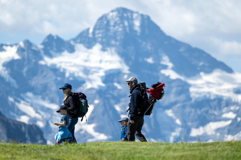Wanderer geniessen die Aussicht auf die Bergwelt, am Sonntag, 3. Juli 2022, auf dem Maennlichen oberhalb von Grindelwald. (KEYSTONE/Peter Schneider)