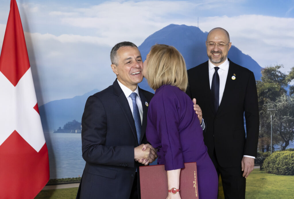 Swiss President Ignazio Cassis, Minister of Foreign Affairs, left, welcomes Elizabeth Truss of the United Kingdom, Foreign, Commonwealth and Development Secretary of the UK, center, next to Ukrainian Prime Minister Denys Shmyhal during the Ukraine Recovery Conference URC, Monday, July 4, 2022 in Lugano, Switzerland. The URC is organised to initiate the political process for the recovery of Ukraine after the attack of Russia to its territory. (KEYSTONE/EDA/Michael Buholzer)