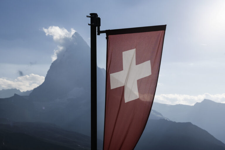 Eine Schweizer Flagge und das Matterhorn in der Abendsonne, fotografiert am Sonntag, 24. Juli 2022 in Zermatt. (KEYSTONE/Christian Beutler)