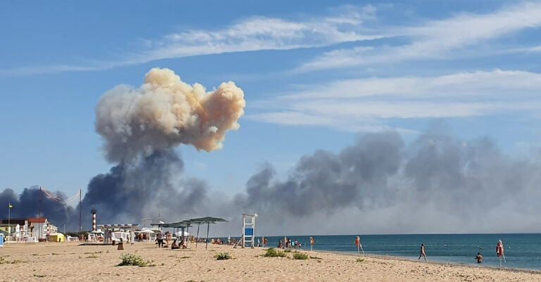 Rising smoke can be seen from the beach at Saky after explosions were heard from the direction of a Russian military airbase near Novofedorivka, Crimea, Tuesday Aug. 9, 2022. The explosion of munitions caused a fire at a military air base in Russian-annexed Crimea Tuesday but no casualties or damage to stationed warplanes, Russia's Defense Ministry said. (KEYSTONE/UGC via AP)
