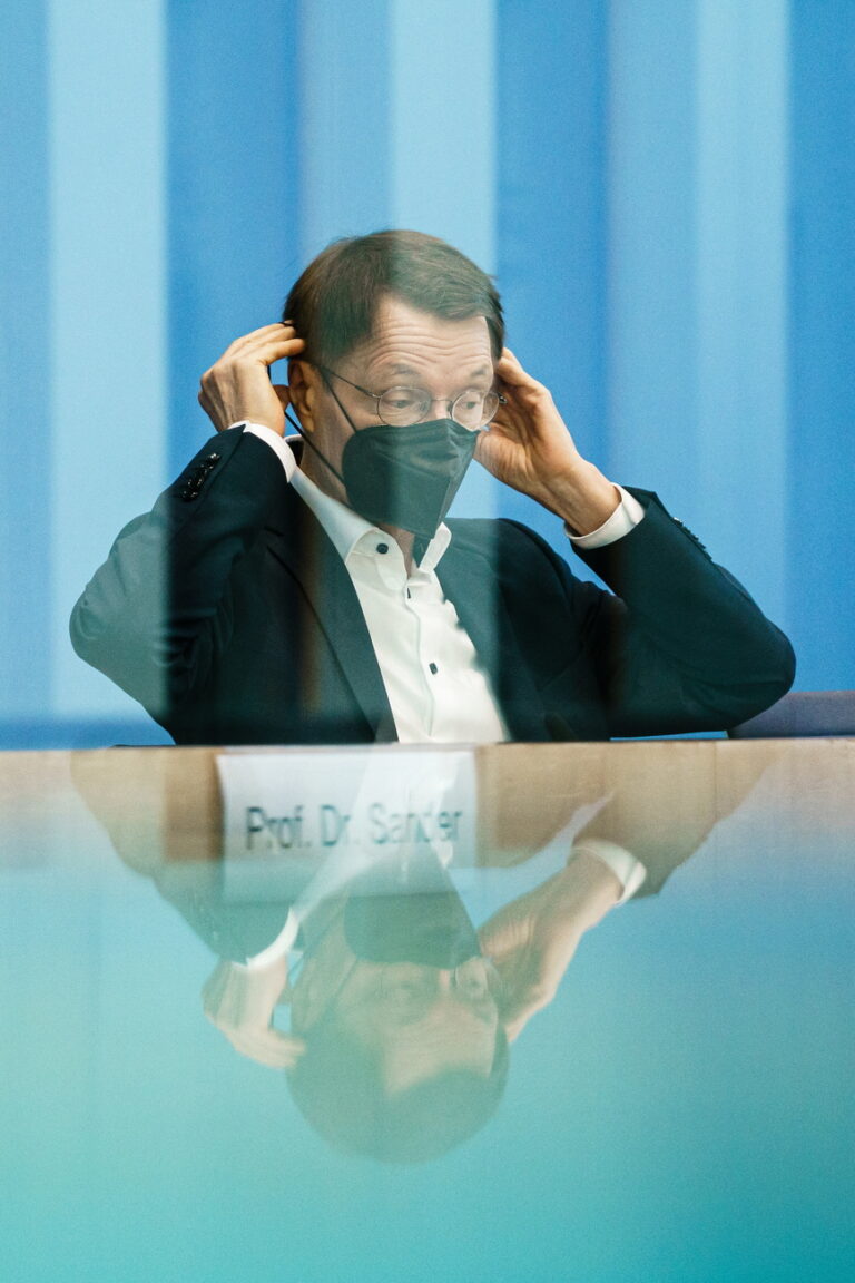 epa10116941 German Health Minister Karl Lauterbach puts on a face mask after speaking during a press conference on the COVID-19 situation at the House of the Federal Press Conference (Bundespressekonferenz) in Berlin, Germany, 12 August 2022. EPA/CLEMENS BILAN