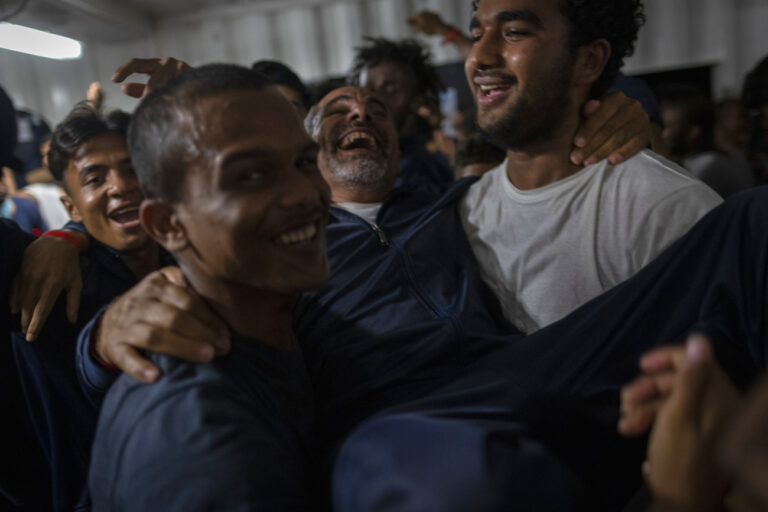 Migrants react upon being given the news that Italy has granted the port of Taranto to disembark, aboard the Ocean Viking, a migrant search and rescue ship run by NGOs SOS Mediterranee and the International Federation of Red Cross (IFCR), Friday Sept.2, 2022. (KEYSTONE/AP Photo/Jeremias Gonzalez)