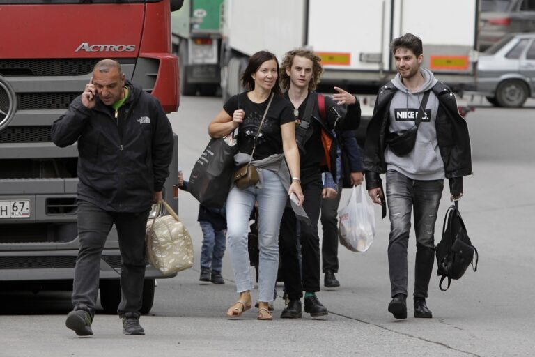 A group of young Russians walk after they crossed the border crossing Verkhny Lars between Georgia and Russia on Friday, Sept. 23, 2022. Long lines of vehicles have formed at a border crossing between Russia's North Ossetia region and Georgia after Moscow announced a partial military mobilization. A day after President Vladimir Putin ordered a partial mobilization to bolster his troops in Ukraine, many Russians are leaving their homes. (AP Photo/Shakh Aivazov)
