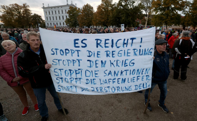 03.10.2022, Mecklenburg-Vorpommern, Schwerin: Teilnehmer einer Demonstration gegen die Energiepolitik versammeln sich vor dem Schweriner Schloss, auf einem Transparent steht 