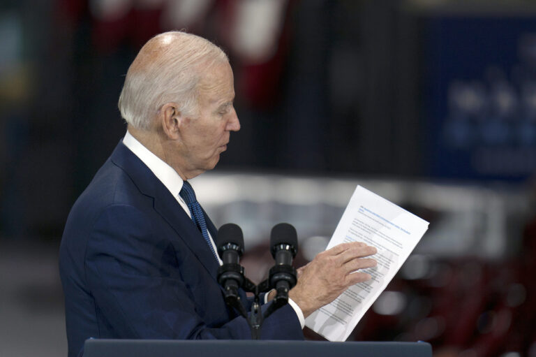 President Joe Biden looks at a document as he speaks at the Volvo Group Powertrain Operations facility in Hagerstown, Md., Friday, Oct. 7, 2022. (AP Photo/Julio Cortez)