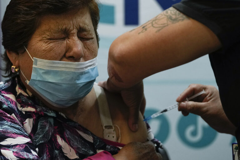 A woman receives a COVID-19 bivalent booster at the start of a vaccination campaign for people 80 years and older, in Santiago, Chile, Wednesday, Oct. 26, 2022. (AP Photo/Esteban Felix)