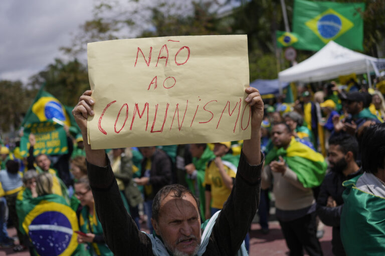 A supporter of Brazilian President Jair Bolsonaro holds a sign that reads in Portuguese: 