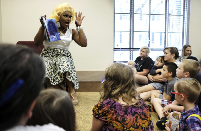 FILE - In this Sept. 8, 2018, file photo, a drag performer by the name of Champagne Monroe reads the children's book 