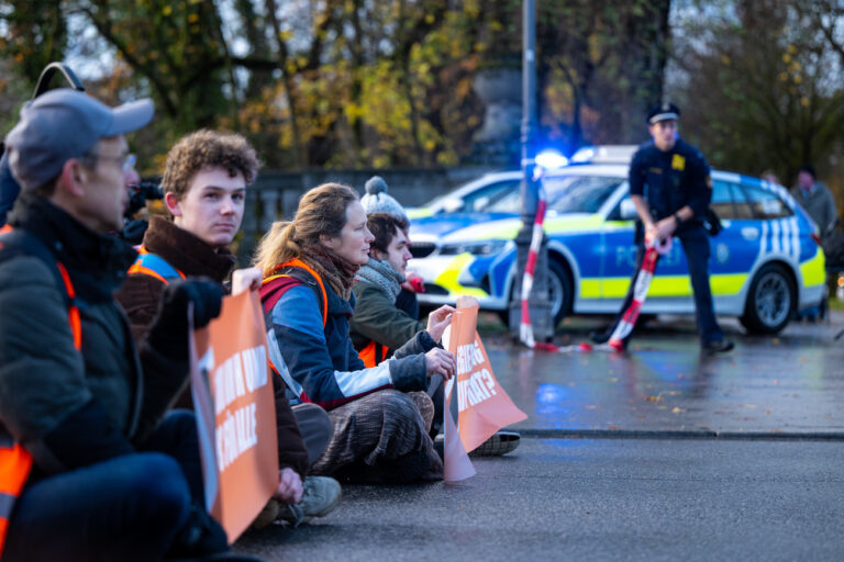 21.11.2022, Bayern, München: Klimaaktivisten der Umweltschutzbewegung «Letzte Generation» sitzen auf der Prinzregentenstraße und blockieren den Verkehr. Foto: Lennart Preiss/dpa +++ dpa-Bildfunk +++ (KEYSTONE/DPA/Lennart Preiss)