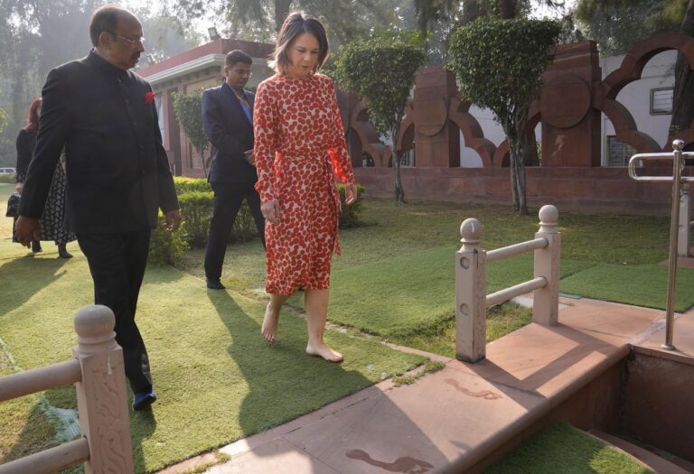German Foreign Minister Annalena Baerbock, returns barefoot after paying her respect at the Gandhi Smriti, a place where Mahatma Gandhi spent the last days of his life and was assassinated, in New Delhi, Monday, Dec. 5, 2022. Baerbock is on a two days official visit to India. (AP Photo/Manish Swarup)