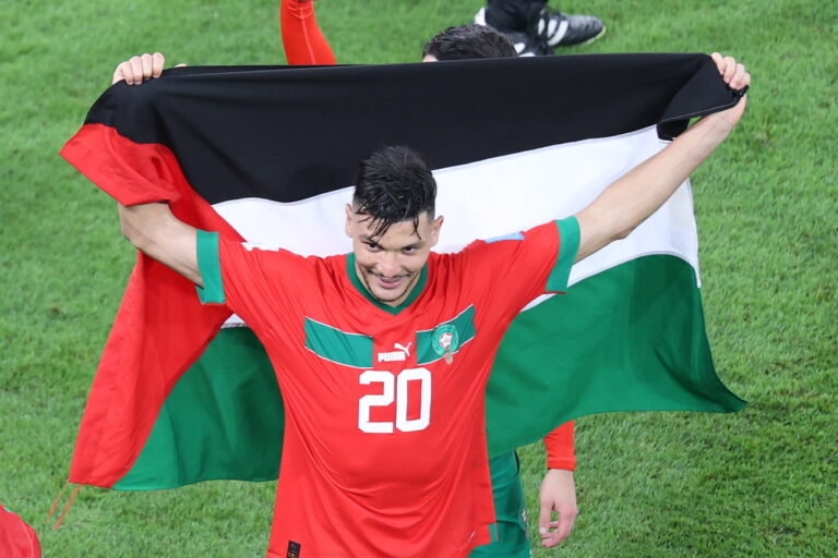 epa10359653 Achraf Dari of Morocco celebrates with the Palestinian Flag after the FIFA World Cup 2022 quarter final soccer match between Morocco and Portugal at Al Thumama Stadium in Doha, Qatar, 10 December 2022. EPA/Abedin Taherkenareh