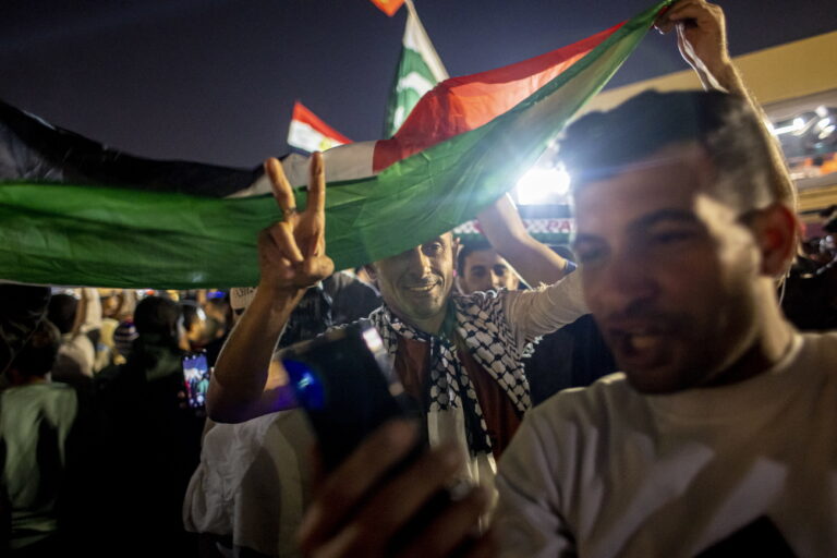 epa10360062 Fans wave the flag of Palestine as they celebrate Morocco winning the FIFA World Cup 2022 quarter final soccer match between Morocco and Portugal, at Souq Waqif market in Doha, Qatar, 10 December 2022. EPA/MARTIN DIVISEK