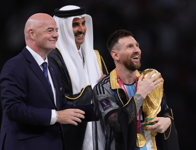 epa10373010 Lionel Messi (R) of Argentina celebrates with the World Cup trophy next to Tamim bin Hamad Al Thani (C), the Emir of Qatar, and FIFA President Gianni Infantino (L) during the trophy ceremony after the FIFA World Cup 2022 Final between Argentina and France at Lusail stadium, Lusail, Qatar, 18 December 2022. EPA/Friedemann Vogel