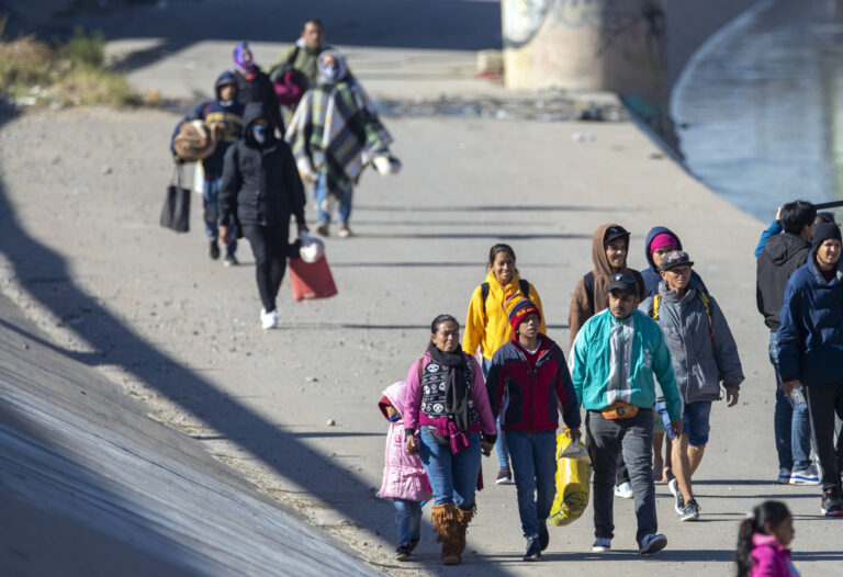 Migrant families walk in the southern bank of the Rio Grande in their attempt to enter into El Paso, Texas from Ciudad Juarez, Mexico, Wednesday, Dec. 21, 2022. Thousands of migrants gathered along the Mexican side of the southern border Wednesday, camping outside or packing into shelters as they waited for the U.S. Supreme Court to decide whether and when to lift pandemic-era restrictions that have prevented many from seeking asylum. (AP Photo/Andres Leighton)