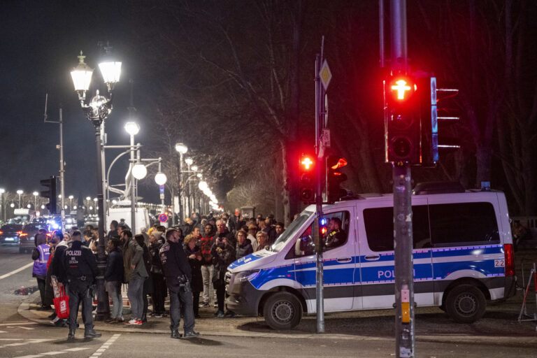 31.12.2022, Berlin: Ein Polizeiauto steht auf dem Gehweg in der Nähe vom Brandenburger Tor neben einer Menschenmenge. Foto: Christophe Gateau/dpa +++ dpa-Bildfunk +++ (KEYSTONE/DPA/Christophe Gateau)