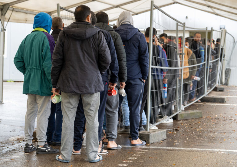 ARCHIV - 16.11.2022, Baden-Württemberg, Ellwangen: In der Landeserstaufnahmestelle (LEA) warten Flüchtlinge in einer Schlange vor der Essensausgabe. (zu dpa 