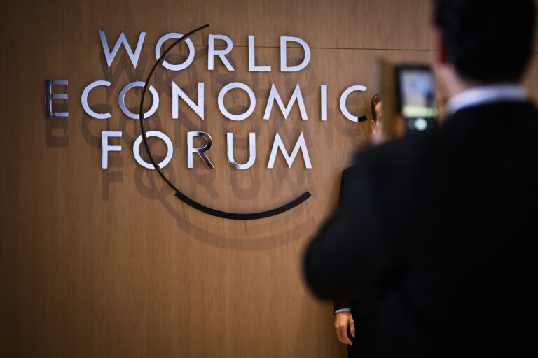 A participant has a picture taken in front of the WEF logo on the closing day of the 53rd annual meeting of the World Economic Forum, WEF, in Davos, Switzerland, Friday, January 20, 2023. The meeting brings together entrepreneurs, scientists, corporate and political leaders in Davos under the topic 