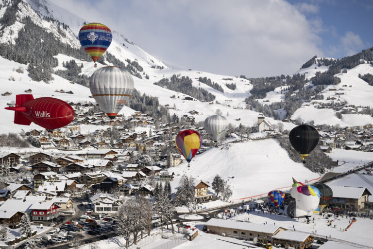 Hot air balloons take off during the 43th International Hot Air Balloon week, in the skiing resort of Chateau-d'Oex, in the Swiss Alps, Saturday, January 21, 2023. Postponed twice because of the pandemic, The International Hot Air Balloon Festival of Chateau-d'Oex (VD) returns this year for a 43rd edition. 60 balloons from 15 countries will be taking part in the event between the 21th and the 29nth of January in the Swiss mountain resort is famous for ideal flight conditions due to an exceptional microclimate. (KEYSTONE/Anthony Anex)