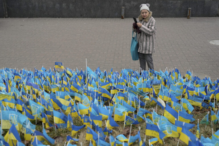 A woman takes a picture at the memorial for those killed during the war, near Maidan Square in central Kyiv, Ukraine, Friday, Feb. 24, 2023. Ukraine's president pledged to push for victory in 2023 as he and other Ukrainians on Friday marked the somber first anniversary of the Russian invasion that he called 