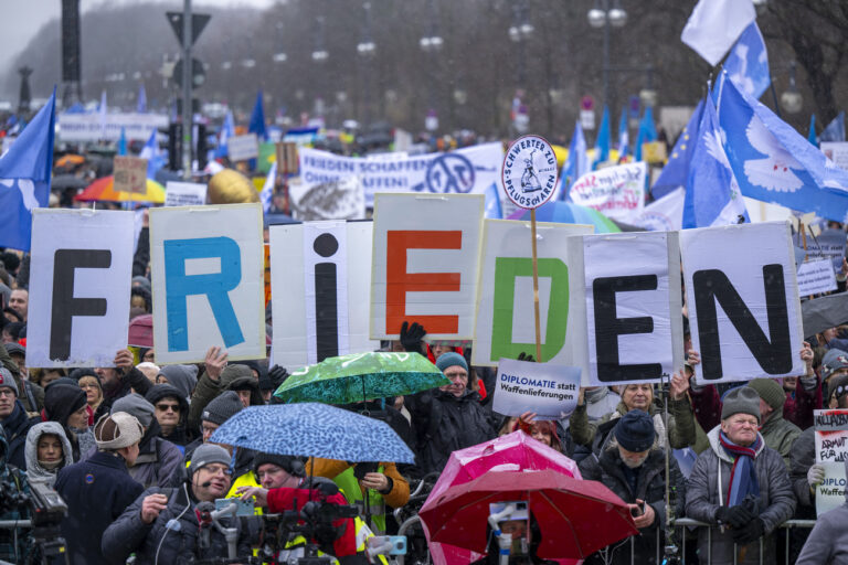 25.02.2023, Berlin: Demonstranten bilden das Wort Frieden mit ihren Schildern. Am Brandenburger Tor in Berlin haben sich mehrere Tausend Menschen zu einer Kundgebung für Verhandlungen mit Russland im Ukraine-Krieg versammelt. Foto: Monika Skolimowska/dpa +++ dpa-Bildfunk +++ (KEYSTONE/DPA/Monika Skolimowska)