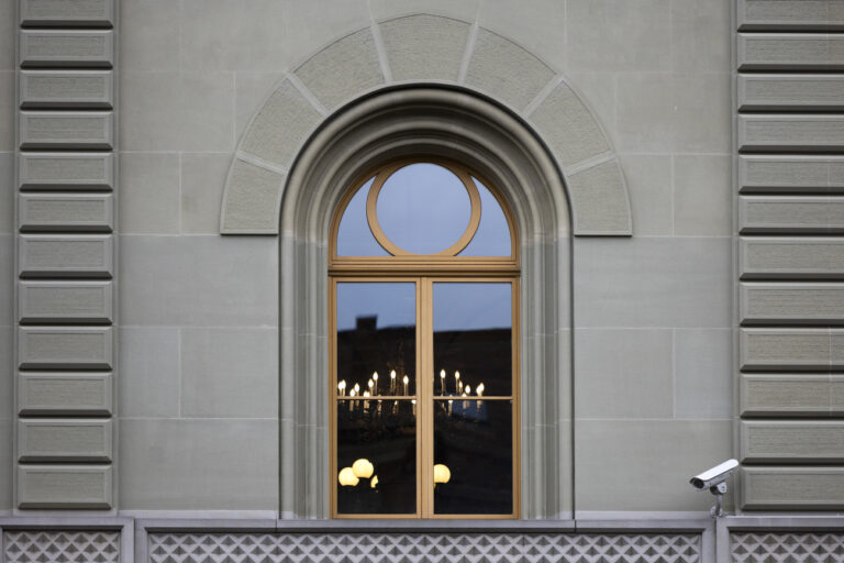Light behind a window in the government building Bundeshaus, on Sunday, 19 March 2023 in Bern. The Federal Council, the Swiss National Bank and representatives of banks meet at the Bernerhof to negotiate the rescue of Credit Suisse or a possible merger with UBS. (KEYSTONE/Peter Klaunzer)
