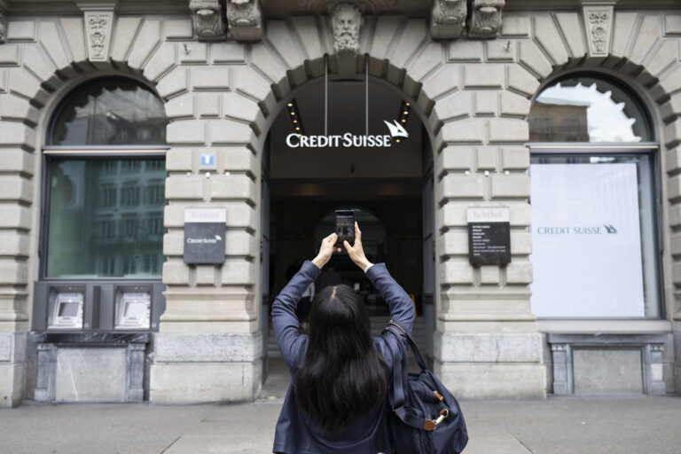 A woman takes photos of a logo of the Swiss bank Credit Suisse in Zurich, Switzerland, 20 March 2023. The bank UBS takes over Credit Suisse for 2 billion US dollars. Shares of Credit Suisse lost more than one-quarter of their value on 15 March 2023, hitting a record low after its biggest shareholder, the Saudi National Bank, told outlets that it would not inject more money into the ailing Swiss bank. (KEYSTONE/Ennio Leanza)
