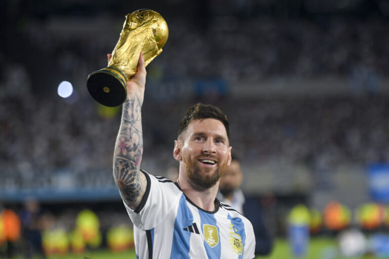 Argentina's Lionel Messi hoists the winning team replica of the FIFA World Cup trophy during a celebration ceremony for local fans after an international friendly soccer match against Panama at the Monumental stadium in Buenos Aires, Argentina, Thursday, March 23, 2023. (AP Photo/Gustavo Garello)