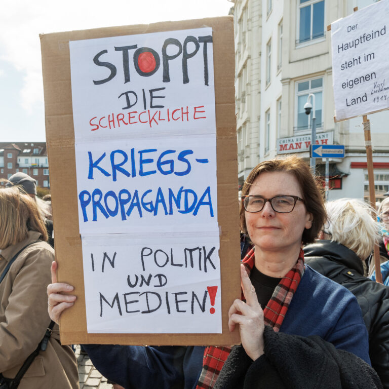 10.04.2023, Hamburg: Eine Teilnehmerin des Hamburger Ostermarschs hält ein Transparent mit der Aufschrift 