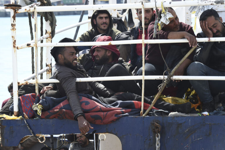 Migrants wait to disembark from a ship in the Sicilian port of Catania, Wednesday, April 12, 2023. Italy's right-wing government has declared a state of emergency to help it cope with a surge in migrants arriving on the country's southern shores. Premier Giorgia Meloni and her Cabinet on Tuesday, decided to impose the emergency status for six months. (AP Photo/Salvatore Cavalli)