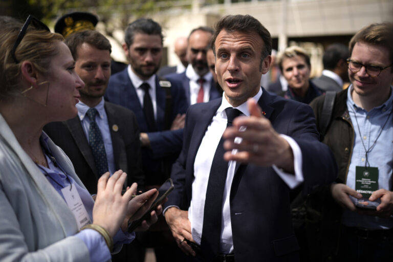 French President Emmanuel Macron talks to journalists as he visits a middle school Thursday, April 20, 2023 in Ganges, southern France. Emmanuel Macron's trip to Ganges comes amid a concerted new effort by him and his government to put the furor caused by the pension change behind him. (AP Photo/Daniel Cole, Pool)