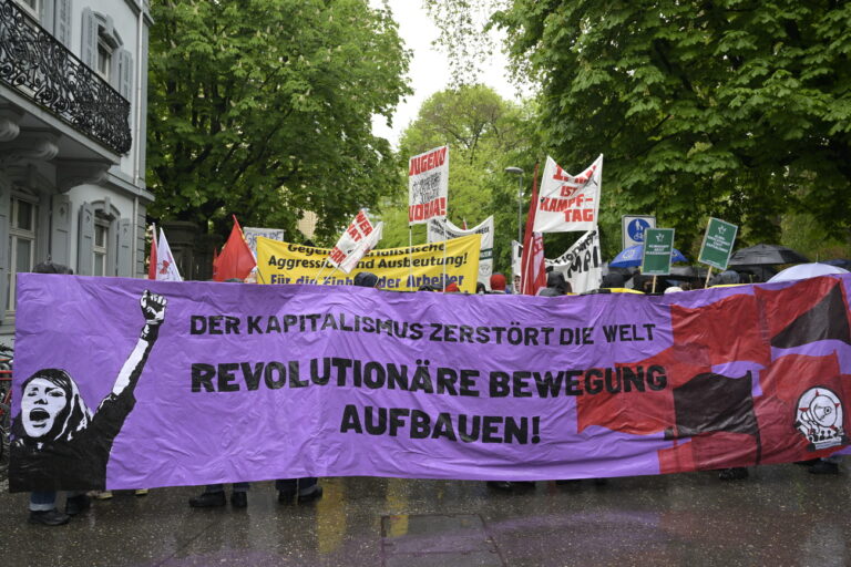 An einer Kundgebung zum Tag der Arbeit demonstrieren Menschen mit Transparenten in Basel, am Montag, 1. Mai 2023. (KEYSTONE/Georgios Kefalas)