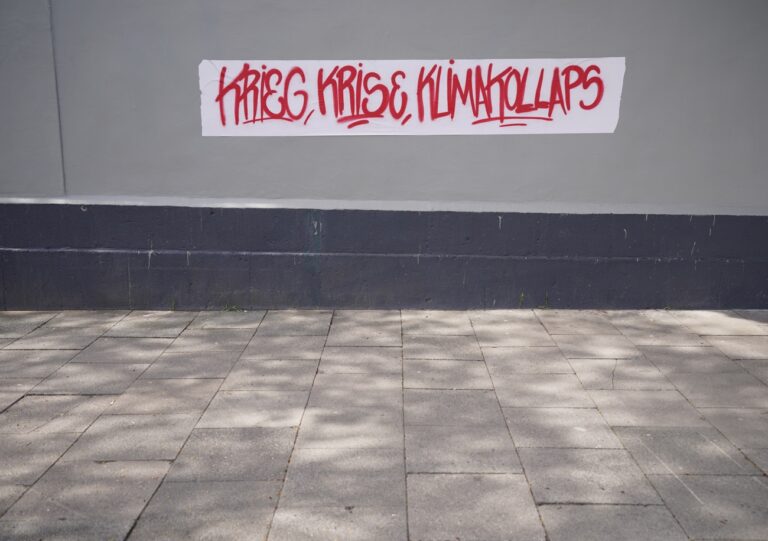 01.05.2023, Hamburg: «Krieg, Krise, Klimakollaps» steht an einer Wand unter einer Brücke während der DGB-Demonstration zum Tag der Arbeit. Die Veranstaltungen des Deutschen Gewerkschaftsbundes zum Tag der Arbeit standen in diesem Jahr unter dem Motto «Ungebrochen solidarisch». Foto: Marcus Brandt/dpa +++ dpa-Bildfunk +++ (KEYSTONE/DPA/Marcus Brandt)