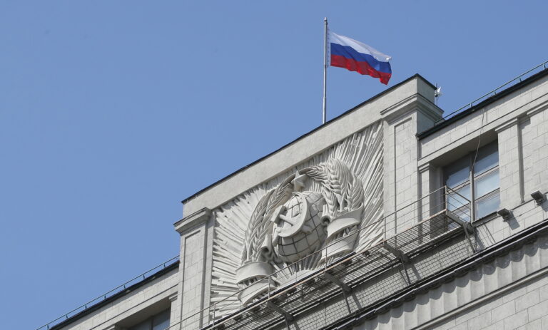 epa10631059 A Russian flag flies above the coat of arms of the Soviet Union on the Russian State Duma building in Moscow, Russia, 16 May 2023. The State Duma (Russia's lower house of parliament) approved a bill denouncing the Treaty on Conventional Armed Forces in Europe (CFE). Russian President Putin submitted the document to the State Duma last week. EPA/MAXIM SHIPENKOV