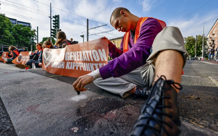 epa10645622 Letzte Generation (Last Generation) climate activists block a road during a climate protest in Berlin, Germany, 22 May 2023. The activists gathered to demand climate councils, the enforcement of speed limits on all German highways and affordable public transport. EPA/HANNIBAL HANSCHKE