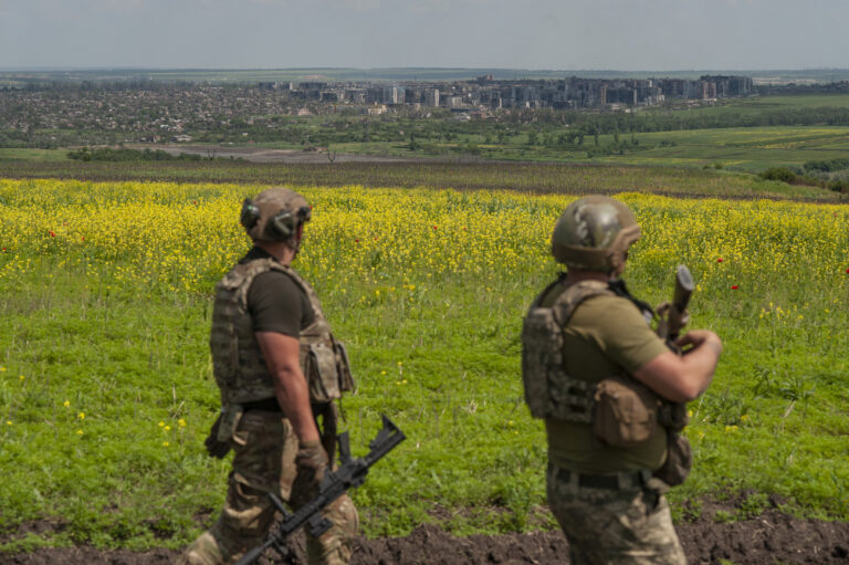 Ukrainian soldiers stand in their positions near Bakhmut, background, in the Donetsk region, Ukraine, Monday, June 5, 2023. (Iryna Rybakova via AP)