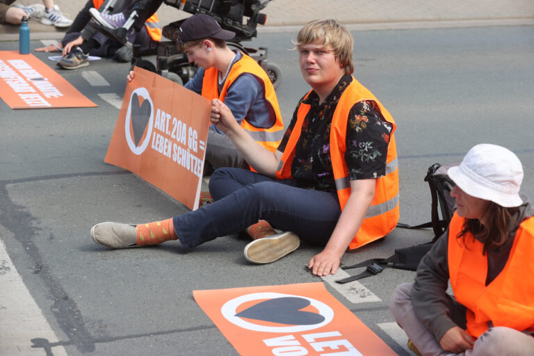 12.06.2023, Thüringen, Jena: Aktivisten der ·Letzten Generation· blockieren eine Straße, auf der sie sich festgeklebt haben. Foto: Bodo Schackow/dpa +++ dpa-Bildfunk +++ (KEYSTONE/DPA/Bodo Schackow)