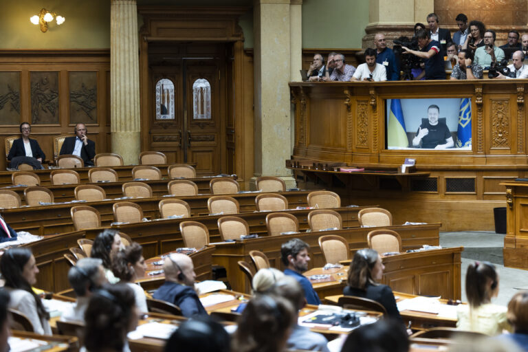Ukrainian President Volodymyr Zelensky is displayed on a screen in front of the empty seats of the members of right wing party SVP during his speech to the members of the Swiss parliament, in Bern, Switzerland, Thursday, June 15, 2023. (KEYSTONE/Peter Klaunzer)