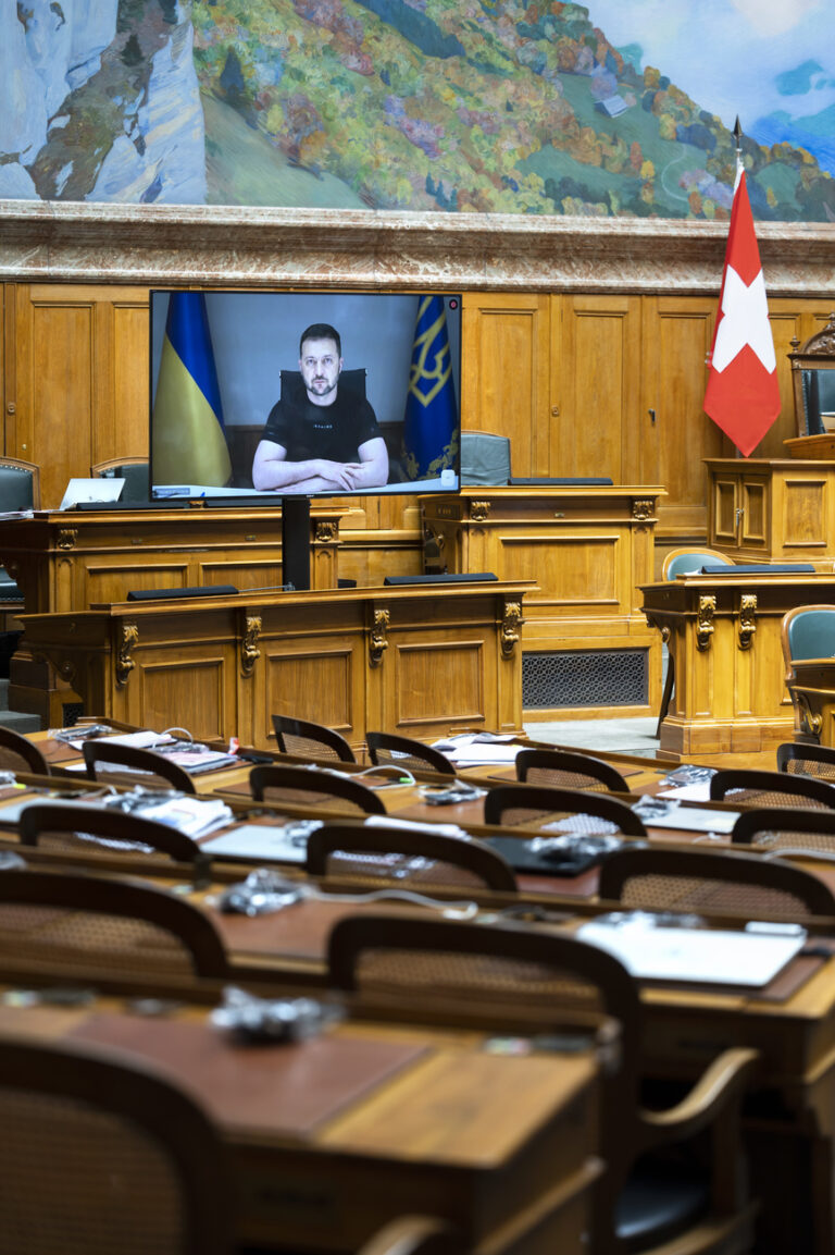 Ukrainian President Volodymyr Zelensky is displayed on a screen in front of the empty seats of the members of right wing party SVP during his speech to the members of the Swiss parliament, in Bern, Switzerland, Thursday, June 15, 2023. (KEYSTONE/Peter Klaunzer)
